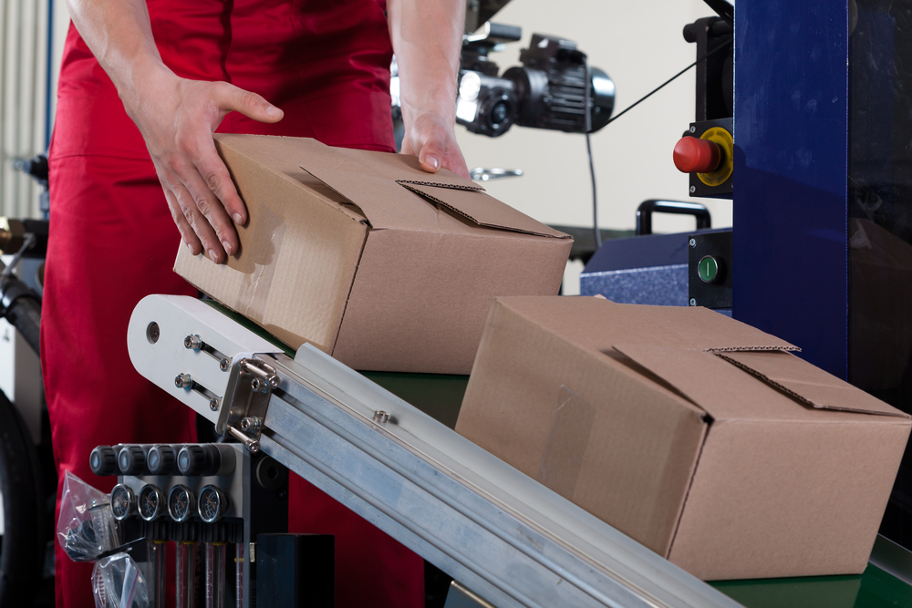 Person placing boxes on conveyor belt